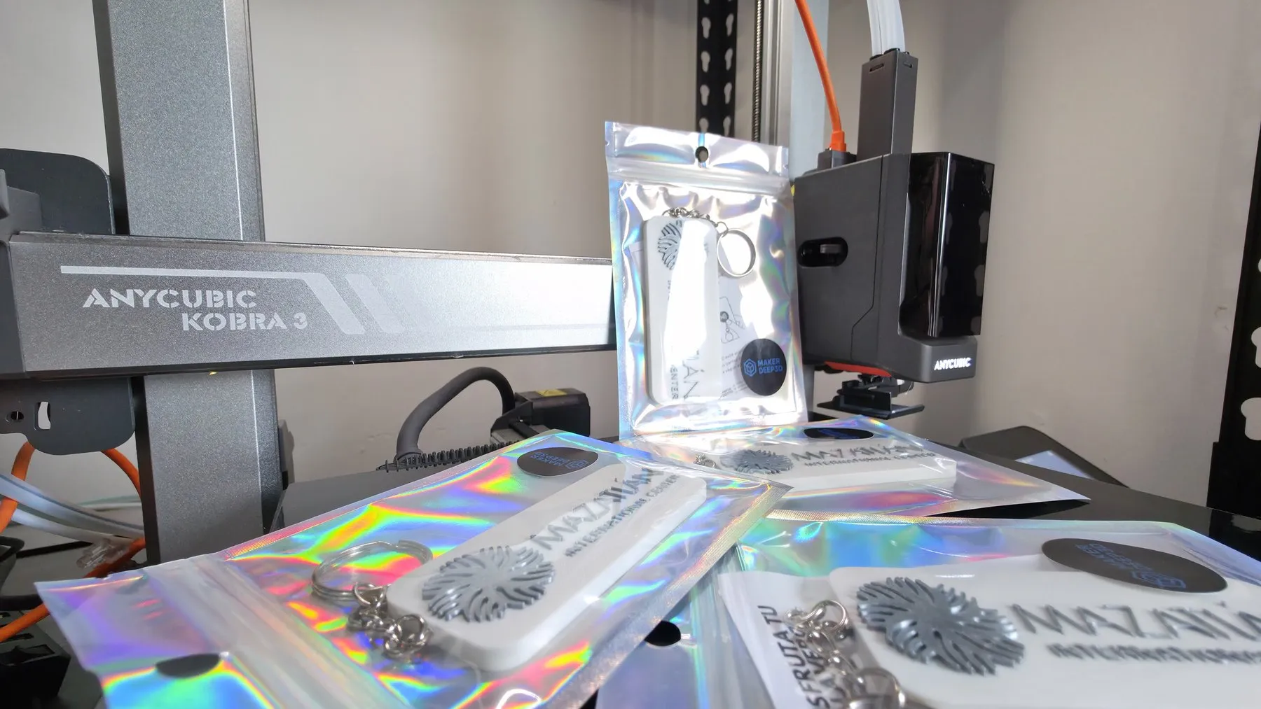 Bag tags del Mazatlán International Center desplegados frente a la impresora 3D que los fabricó